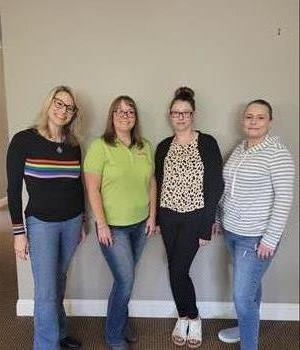 five women smiling and standing posed