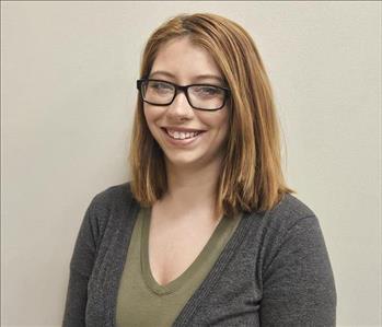 woman with glasses against wall